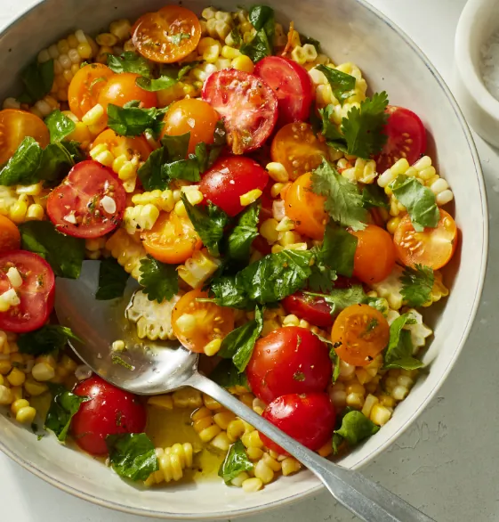 Sungold tomato, sweet corn, and fresh basil salad with sherry vinaigrette. not a real photo