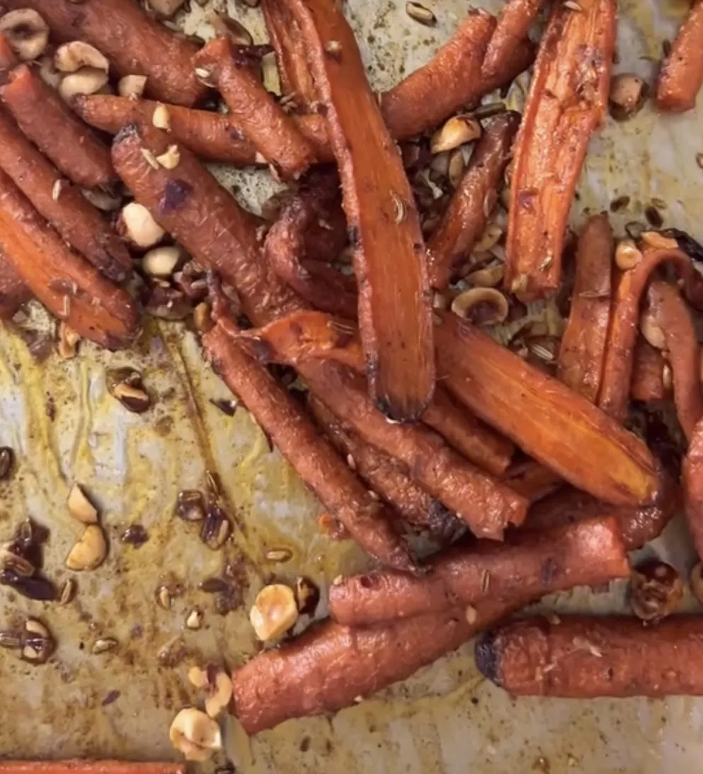 Butter-roasted spiced carrots topped with toasted hazelnuts and fresh herbs.