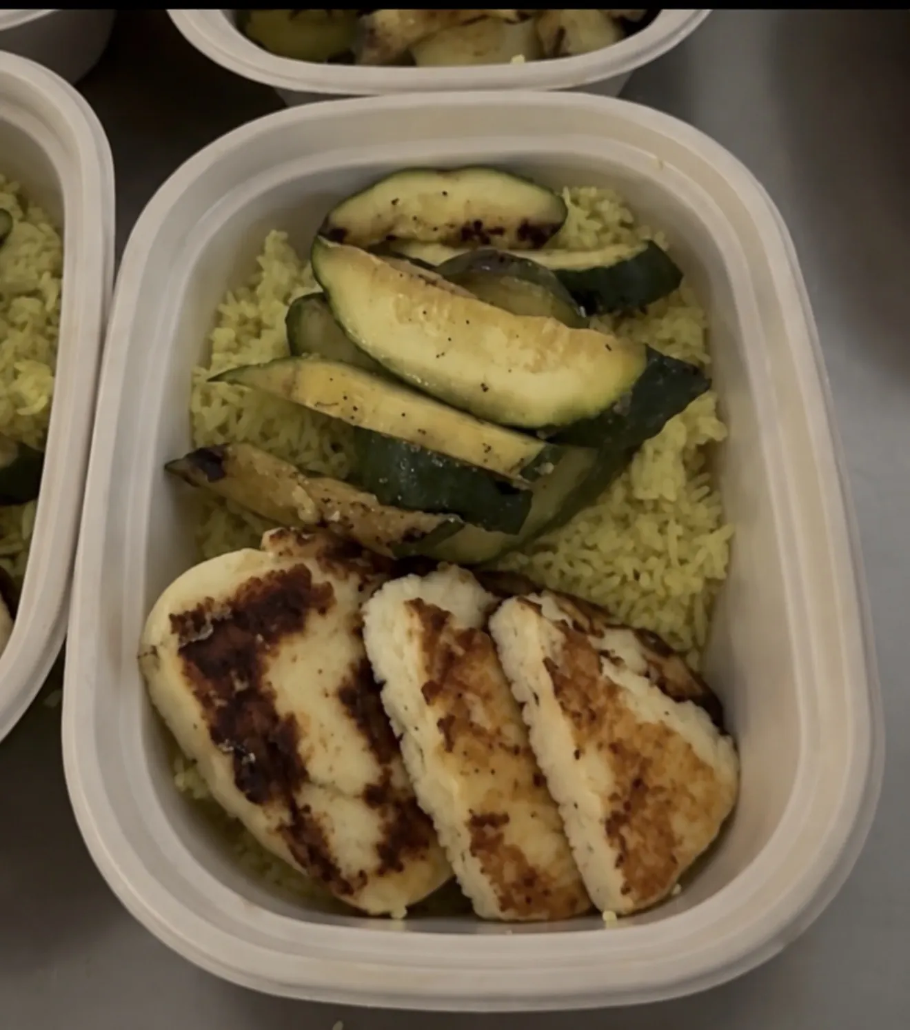 Halloumi rice bowl with turmeric-garlic rice, grilled zucchini, tomato-olive salsa, and lemon-garlic za’atar yogurt.
